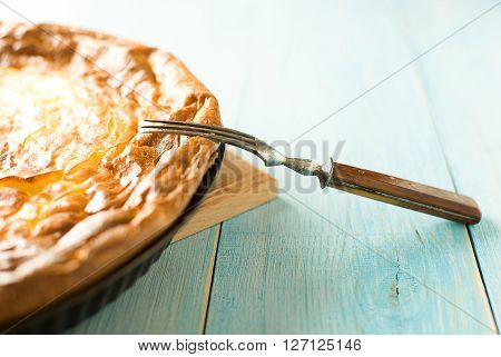 Cheese cake and one fork on over blue
