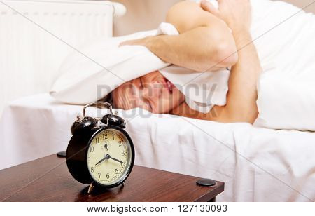 Man trying to sleep, when alarm clock ringing