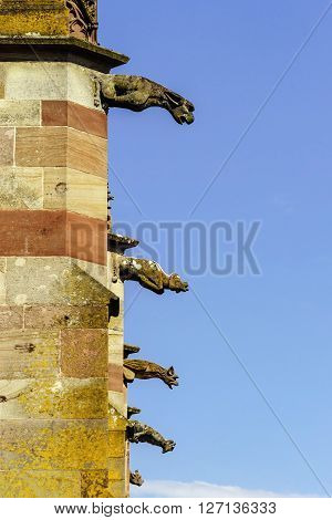 Gargoyle On A Gothic Cathedral, Detail Of A Tower On Blue Sky Background