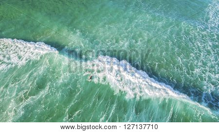 Aerial view of surfer on huge ocean wave