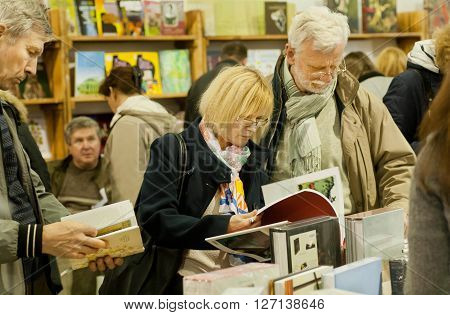 KYIV, UKRAINE - APR 21, 2016: Couple of seniors making choice around the books of the 6th International Festival BOOK ARSENAL on April 21, 2016. Guests of fair were Lars Svendsen Vigdis Hjorth Etgar Keret