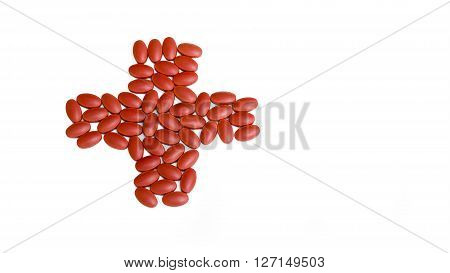Red pills are arranged in cross symbol on the white background