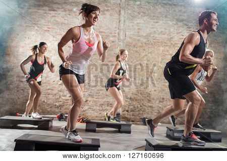 positive and cheerful people doing exercise on steppers
