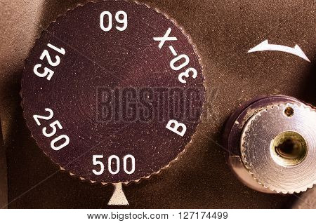 Fragment of old film camera. Top view dial of exposure and shutter button. Close up view. Macro. Selective focu. sVintage photo. Toning.
