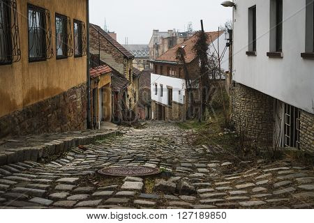 Old medieval narrow stone paved street in Buda district of of Budapest on a foggy day in winter. Shot at Gul Baba utca