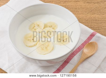 Bowl of Homemade Yoghurt Topping with Ripe Banana Nutritionally Rich in Protein Calcium Riboflavin Vitamin B6 and Vitamin B12.