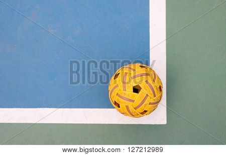 top view of old sepak takraw ball in corner of old blue court