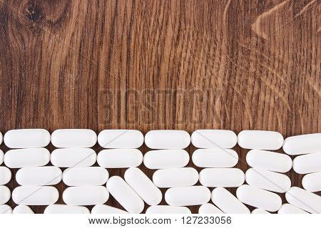 Heap of white medical pills capsules or supplements for therapy concept of treatment and health care copy space for text or inscription