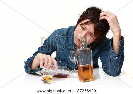 Young Japanese man in depression is drinking alcohol
