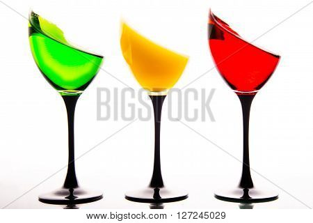 three wine glasses filled with the colors of traffic lights.