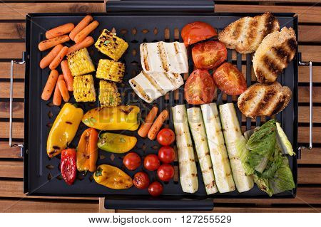Grilled vegetables, bread and cheese on a grilling pan