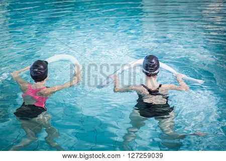 Women in the pool with foam rollers at the leisure center