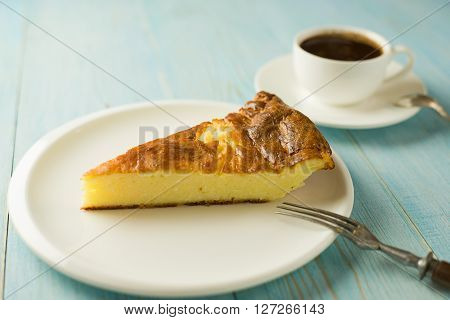 Piece of cake on a white plate on over blue