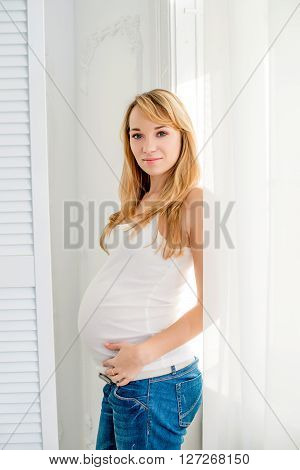 A pregnant woman on a white background in jeans and a white T-shirt
** Note: Visible grain at 100%, best at smaller sizes
