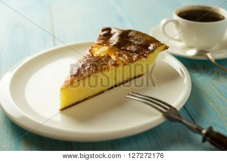 Piece of cake on a white plate on over blue