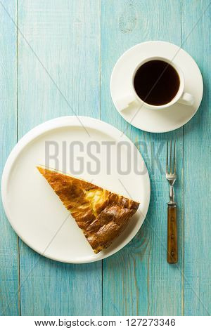 Piece of cake on a white plate on over blue