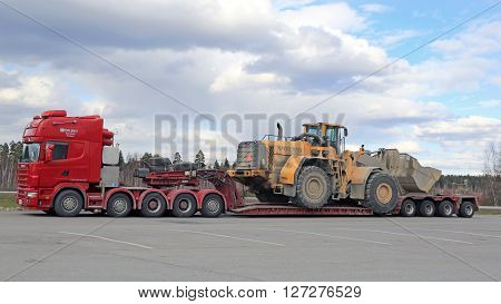 FORSSA, FINLAND - APRIL 23, 2016: Scania 164G truck stops at Forssa truck stop during the oversized transport of heavy Volvo L350F wheel loader side view.