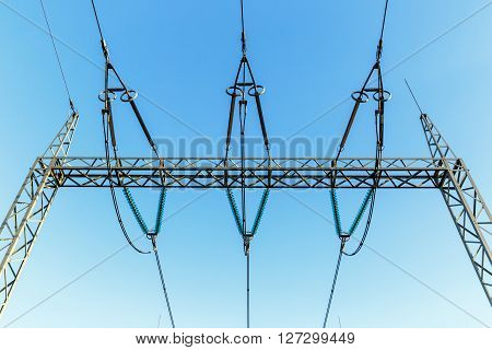 high-voltage electricity pylons against blue sky with clouds