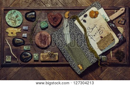 Hand made soap with herbs recipes book and stones flat lay composed