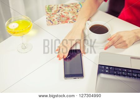 outdoor portrait of a young girl she works as a freelancer in a cafe drinking a delicious hot Cup of coffee from text send mail loads the photo instagram freelancer drinking cappuccino