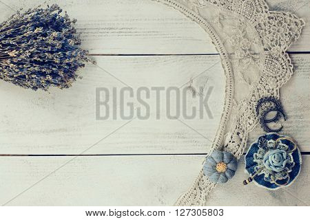 Lavender dried bouquet lace collar and vintage jewellery on rustic background. Romantic home decoration