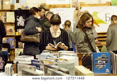 KYIV, UKRAINE - APR 21: Young lady with book reading new stories in crowd of the 6th Festival BOOK ARSENAL on April 21, 2016. Guests of the fair were writers Lars Svendsen Vigdis Hjorth Etgar Keret
