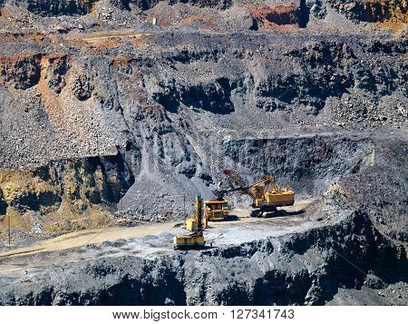Excavator put metal ore to the dump-body track
