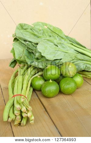 close up green lime yardlong bean and kale on wood floor