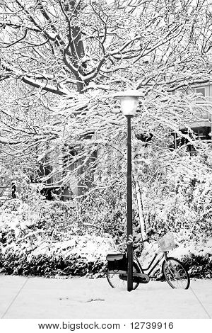 Streetview im Schnee mit Laternenpfahl und Bike