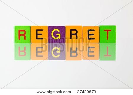 Regret - an inscription from children's wooden blocks