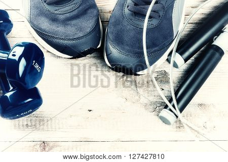 Fitness background with dumbbells sneakers and skipping rope. Healthy lifestyle concept with copy space