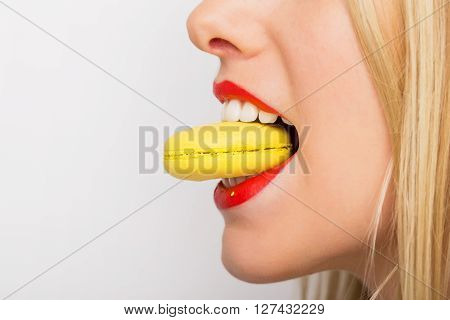 Profile of  beautiful woman eating macaroon cookie