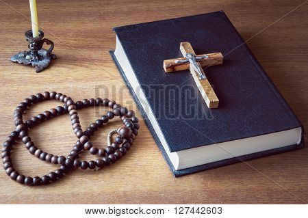 Holy bible, cross and old rosary on wooden background