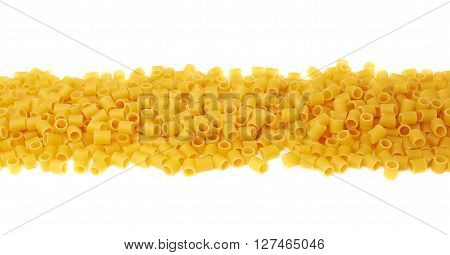 Line made of dry ditalini yellow pasta over isolated white background