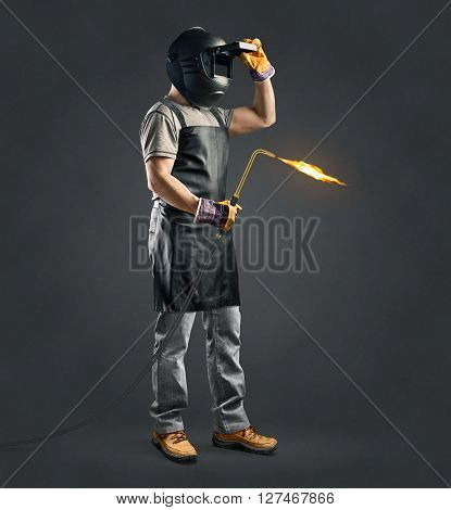 worker welder with gas welding machine on gray background