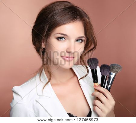 Makeup Artist Professional Stylist Woman Holding Brushes In Hand. Young Smiling Girl Posing At Camer