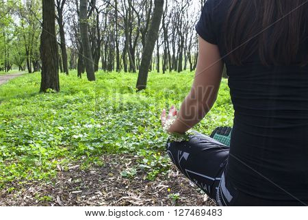 woman practices yoga in the park, meditation and health.
