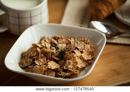Healthy breakfast in the morning served on tray in bed with coffee, cornflakes, croissant and milk