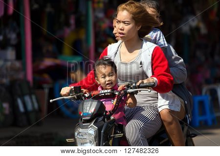THONG PHA PHUM, THAILAND, JANUARY 23, 2016 : Three adults and a child are riding a scooter without helmet protection in the street of Thong Pha Phum, Thailand.