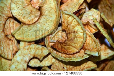 Dried fruit in glass and metallic dishes on wooden ground