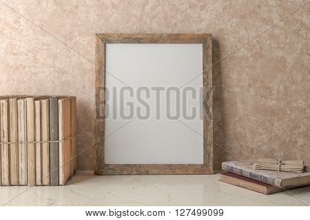 Blank Picture frame on the wall and old books