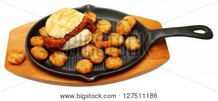 Spicy Chicken Biscuit and Hashbrowns on Skillet isolated over white