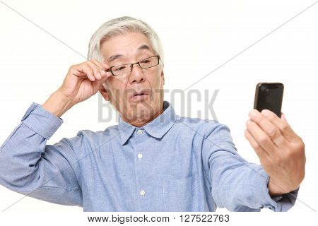 senior Japanese man with presbyopia on white background