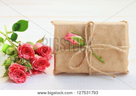 Handmade little gift box, wrapped in parchment paper, fresh roses decor. Handmade gift wrap idea.