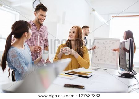 business, startup and people concept - happy creative team or students drinking coffee at office
