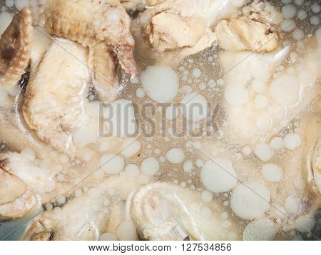 cold boiled chicken wings in frozen greasy chicken bouillon