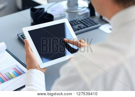 Businessman holding digital tablet and analyzing financial figures