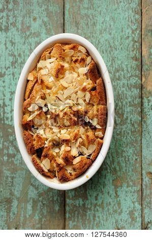 Baked panettone pudding in oval baking dish on oldpainted background overhead view