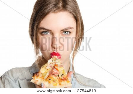Pretty young sexy woman eating big slice of pizza standing on white background