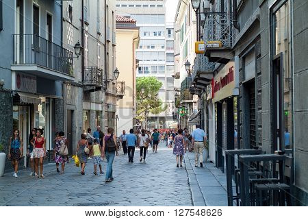Lecco, Italy - September 1st 2015: pedestrians walking past shops and restaurants in a central street in Lecco Italy